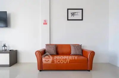 Modern living room with stylish orange sofa and wall art, perfect for contemporary home decor.