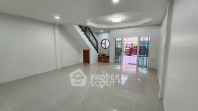 Spacious modern living room with sleek tile flooring and stylish staircase, perfect for contemporary living.