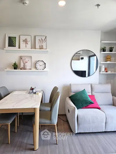 Modern living room with stylish decor, featuring a marble dining table, cozy sofa, and elegant wall art.