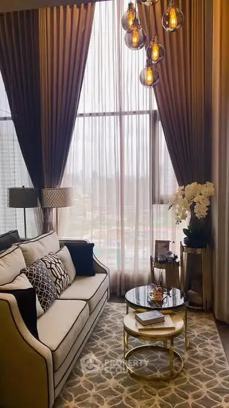 Luxurious living room with high ceilings, elegant chandelier, and large window offering city views.