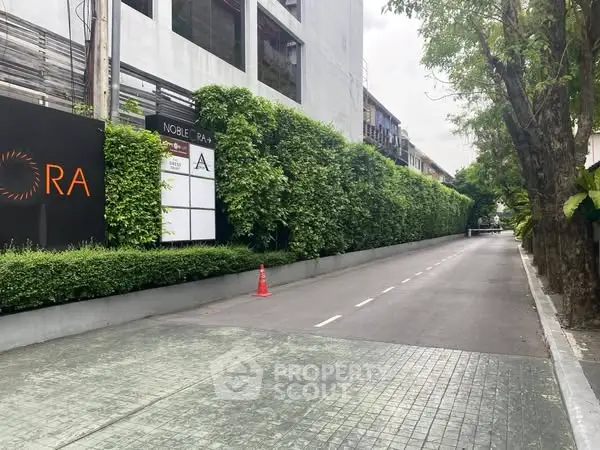 Modern building exterior with lush green wall and private driveway