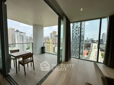 Stunning city view from modern high-rise apartment with spacious balcony and floor-to-ceiling windows.