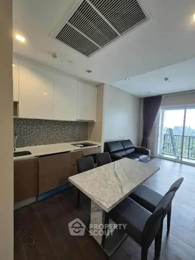 Modern open-layout kitchen with marble dining table and balcony view