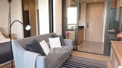 Modern living room with stylish sofa and open kitchen layout in a cozy apartment.