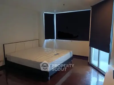 Spacious bedroom with large windows and modern design in a real estate property.