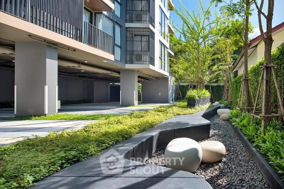 Modern building exterior with lush garden and seating area