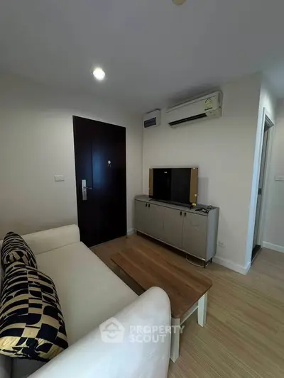 Cozy living room with modern sofa, wooden coffee table, and sleek TV cabinet in a stylish apartment.