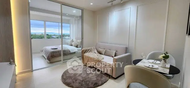 Modern studio apartment with cozy living area and scenic window view.