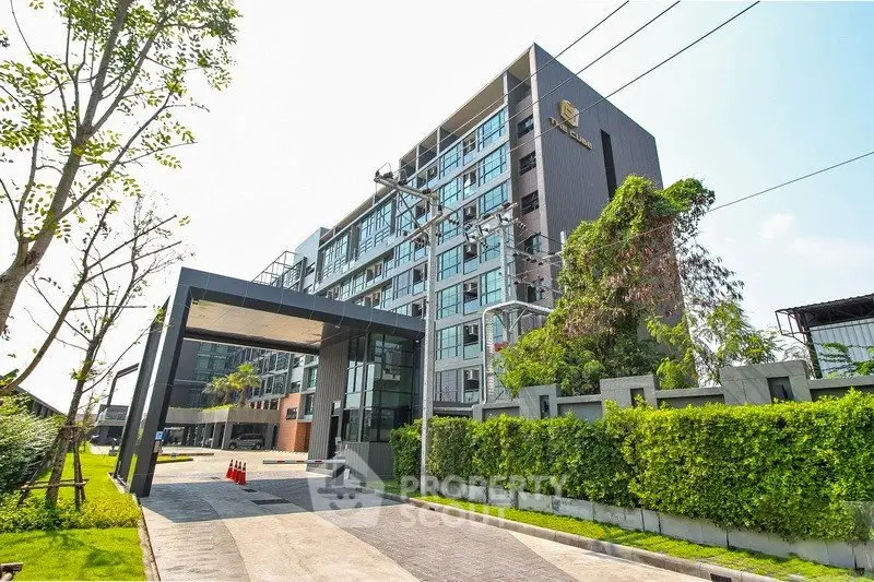 Modern apartment building with lush greenery and sleek entrance