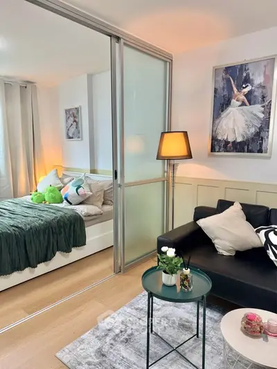 Chic modern apartment with cozy living room and stylish bedroom separated by sliding glass doors.