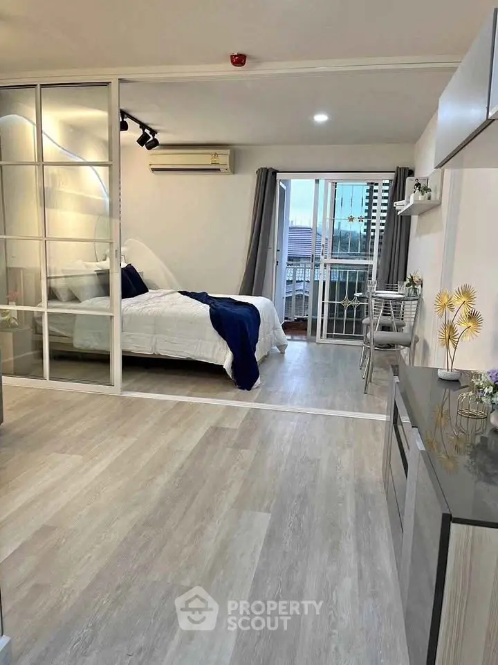 Modern studio apartment with open layout and balcony view.