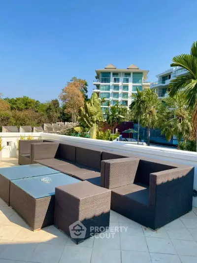 Luxurious outdoor seating area with modern wicker furniture and stunning building view.