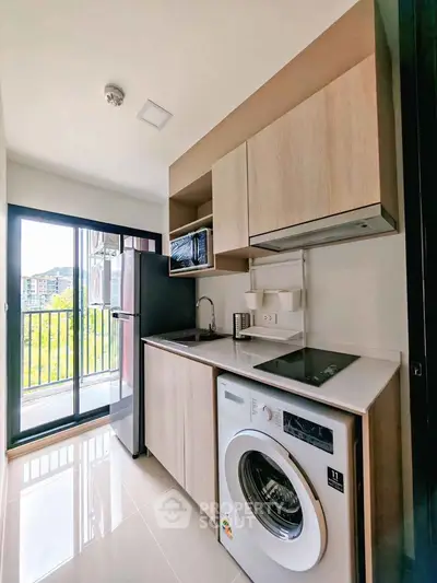 Modern kitchen with washing machine and balcony view in a stylish apartment