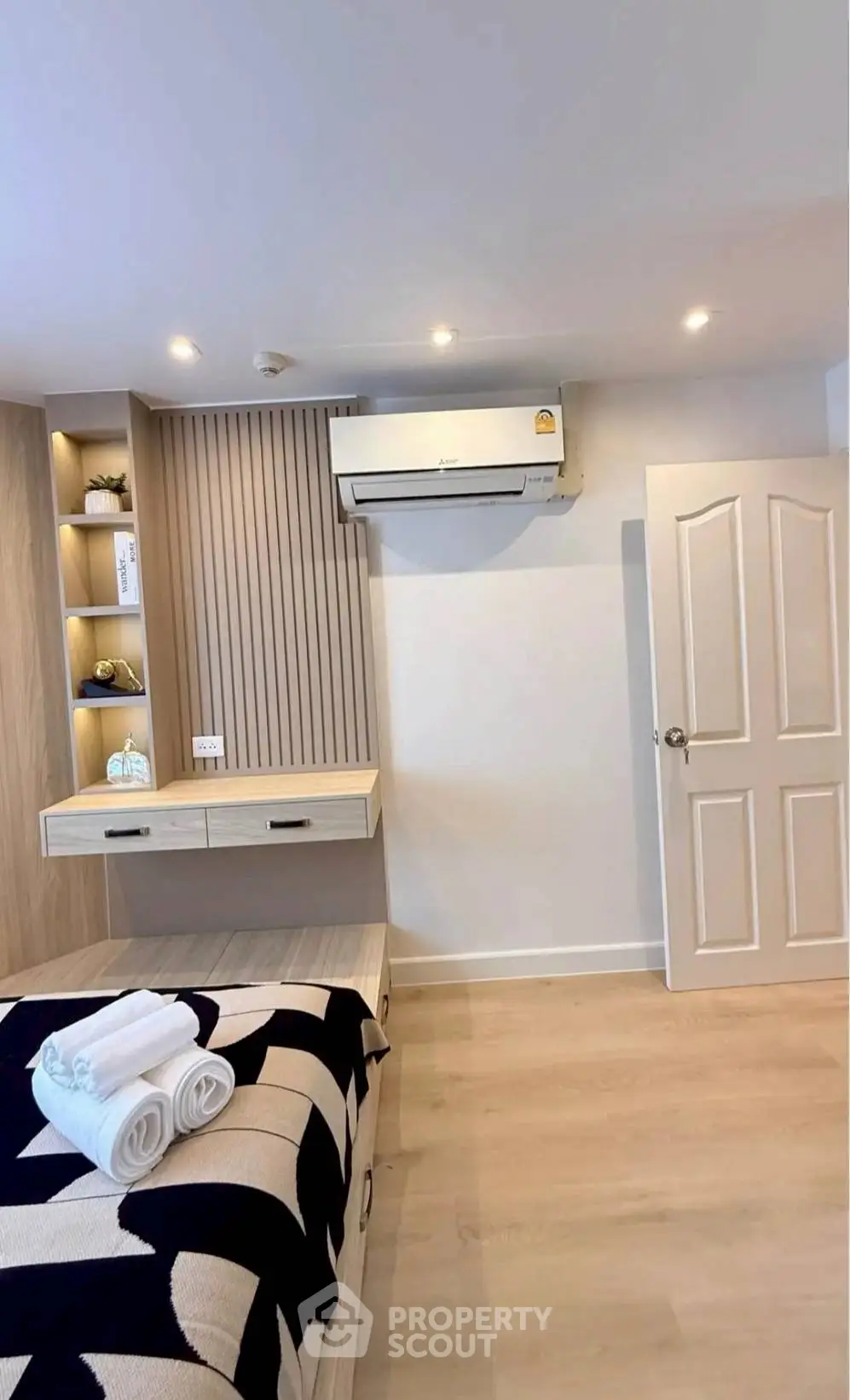 Modern bedroom with stylish decor and air conditioning, featuring cozy bed and elegant lighting.