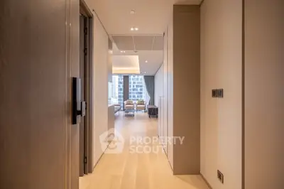 Modern apartment hallway leading to a bright living room with city view.