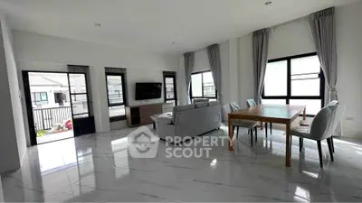 Spacious modern living room with large windows and elegant dining area