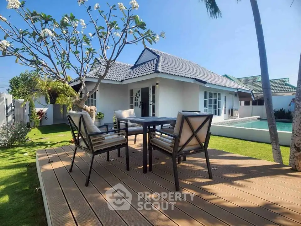 Charming house with outdoor patio and lush garden, perfect for relaxation.