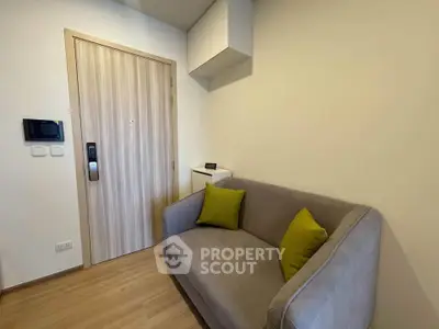 Cozy modern living room with stylish sofa and wooden door, perfect for urban living.