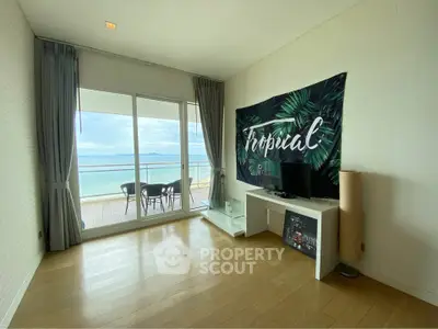 Spacious living room with ocean view and balcony access in modern apartment.