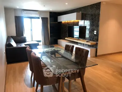 Modern living room with glass dining table and stylish decor in a contemporary apartment.