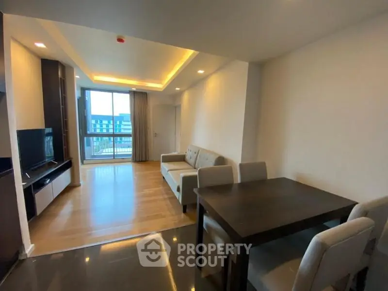 Modern living room with open layout and balcony view in a stylish apartment.