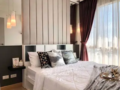 Luxurious bedroom with elegant decor and natural light, featuring plush bedding and stylish curtains.