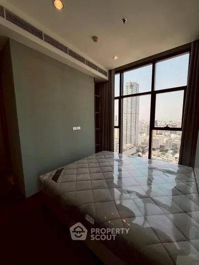 Luxurious bedroom with stunning city view from floor-to-ceiling windows in high-rise apartment.