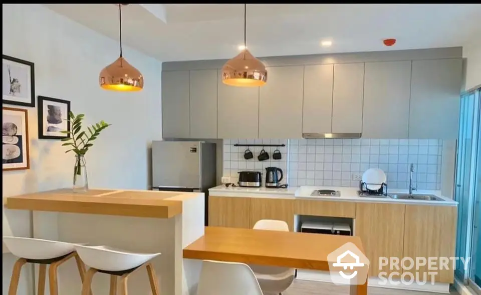 Modern kitchen with sleek cabinetry and stylish lighting in a contemporary apartment.