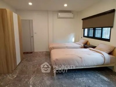 Spacious bedroom with twin beds and modern decor, perfect for comfortable living.