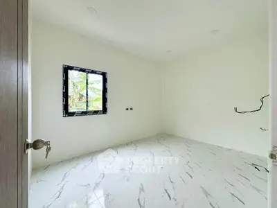 Spacious unfurnished room with marble flooring and a window view of greenery.