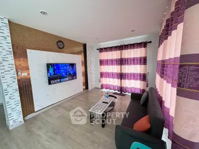 Modern living room with stylish decor, featuring a wall-mounted TV and elegant curtains.