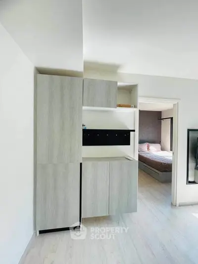 Modern apartment interior with sleek storage and cozy bedroom view