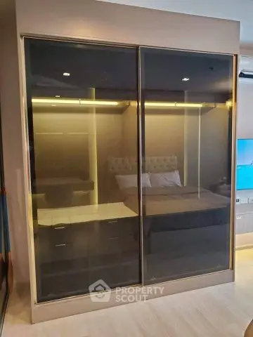 Modern bedroom with sleek glass wardrobe and ambient lighting