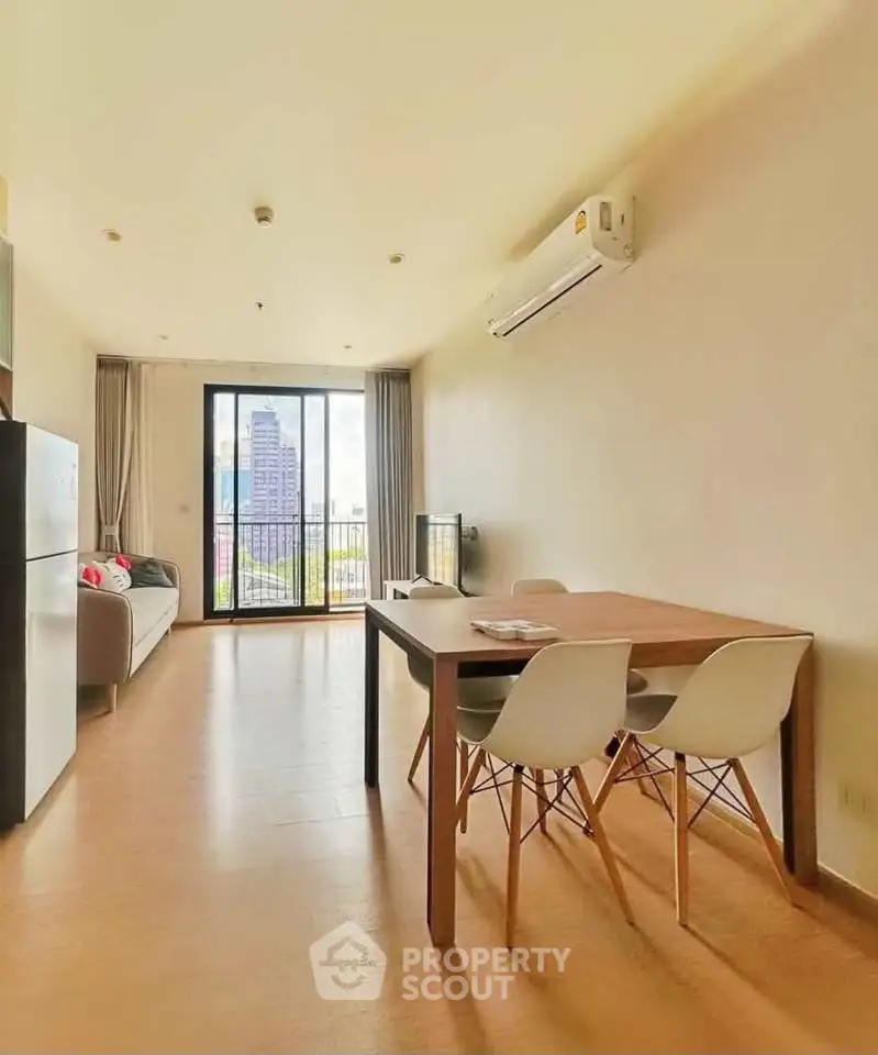 Spacious modern living room with city view, featuring sleek furniture and large windows for natural light.