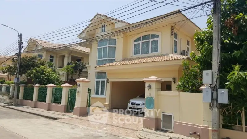 Charming two-story house with driveway and lush greenery in a serene neighborhood.
