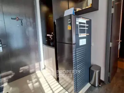 Modern kitchen with sleek black refrigerator and stylish interior design.