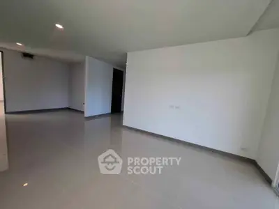 Spacious empty room with modern tiled flooring and recessed lighting, ready for customization.