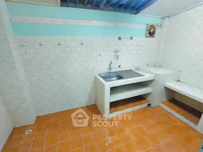 Spacious tiled kitchen with open layout and stainless steel sink