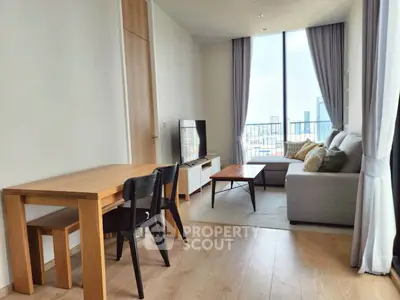 Modern living room with large window and city view, featuring cozy sofa and dining area.