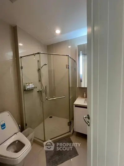 Modern bathroom with glass shower enclosure and sleek fixtures