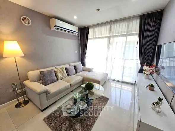 Modern living room with elegant decor, plush sofa, and natural light from large windows.