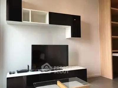 Modern living room with sleek black and white entertainment unit and flat-screen TV.