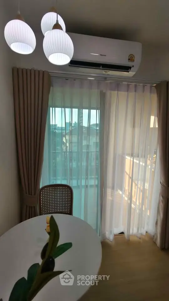 Cozy dining area with modern lighting and balcony view