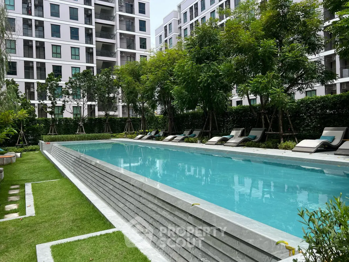 Luxurious apartment complex with a stunning outdoor pool and lush greenery, perfect for relaxation and leisure.