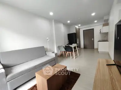 Modern open-plan living room with sleek furniture and integrated kitchen area.