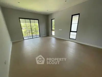 Spacious empty room with large windows and balcony view