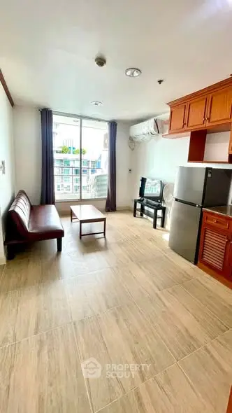Spacious living room with modern furniture and large window offering natural light.