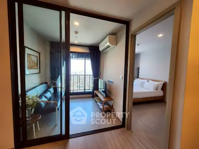 Modern apartment with cozy living room and bedroom, featuring a balcony view.