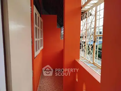 Vibrant orange balcony with city view, perfect for urban living.