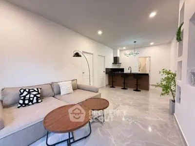 Modern open-plan living room with stylish decor and sleek kitchen area